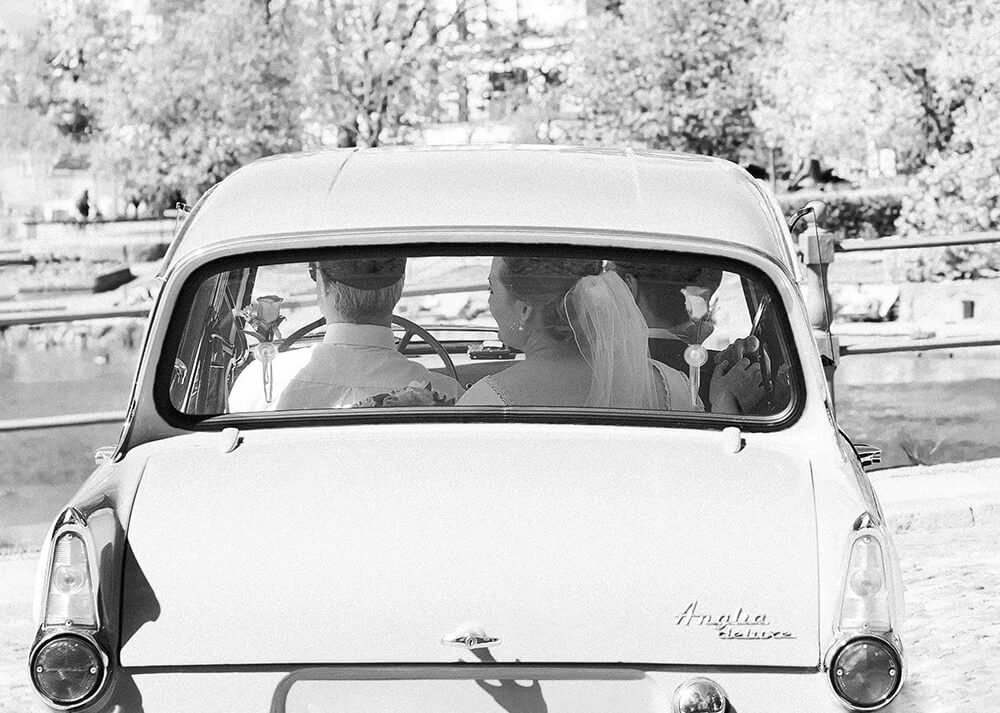 Brud och brudgum i Ford Anglia på bröllopsdagen